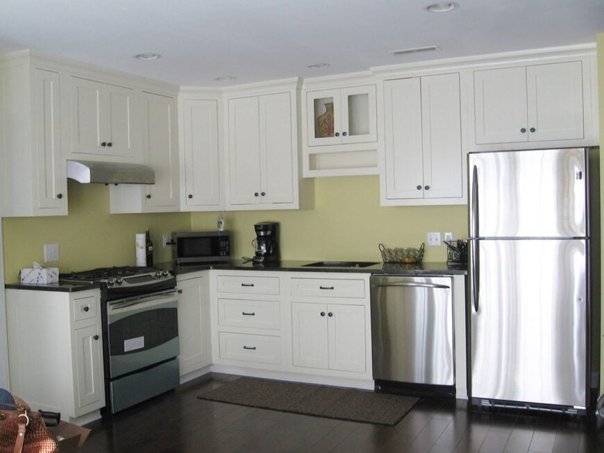 The kitchen is equipped with stainless steel appliances, undermount sink, black granite countertops, and white cabinets.