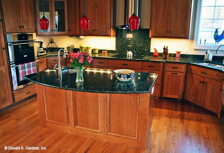 The kitchen is equipped with black granite countertops, stainless steel appliances, undermount sinks, and wooden cabinets.