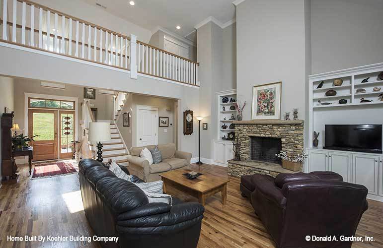 The living room has leather seats, wooden coffee table, and a stone fireplace.