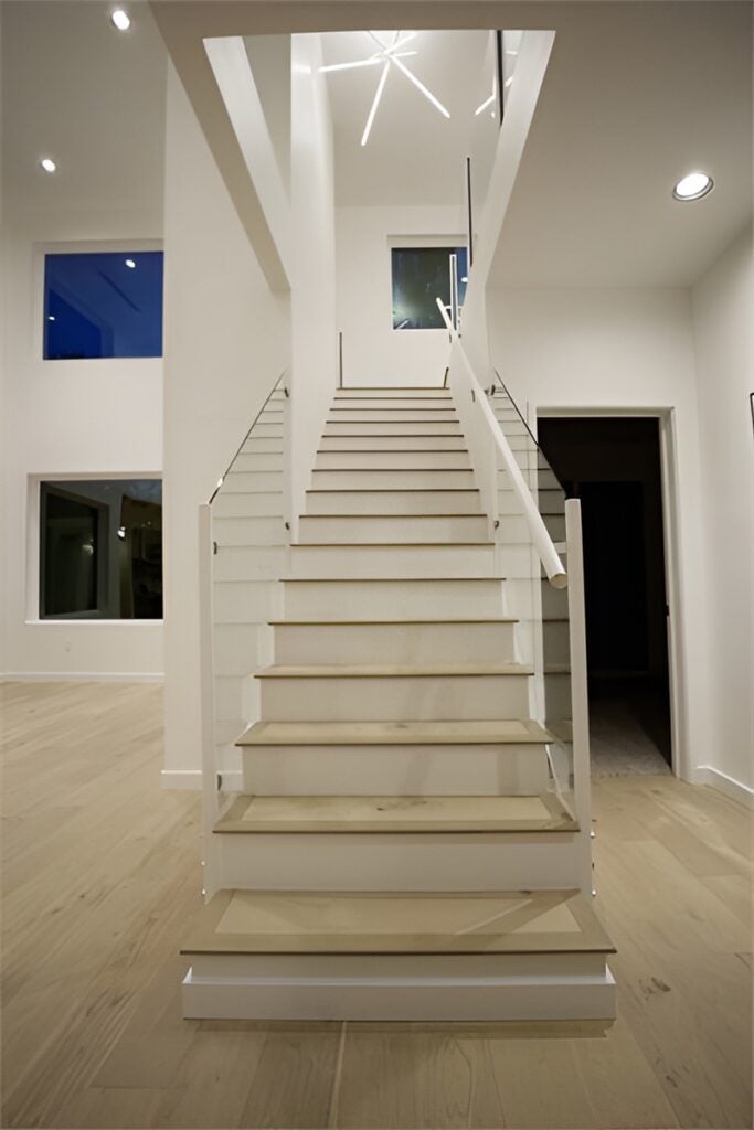 Light wood staircase with glass railings leading to the sleeping quarters.Light wood staircase with glass railings leading to the sleeping quarters.