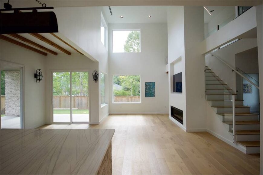 The living room has hardwood flooring, wall-mounted TV, and a modern fireplace.