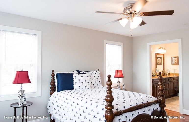 This bedroom offers a wooden bed and round nightstands topped with red table lamps.