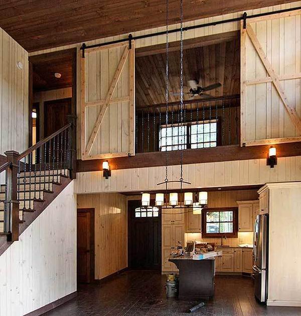 The open kitchen is situated under the second-floor bedroom that's enclosed in a sliding barn door.