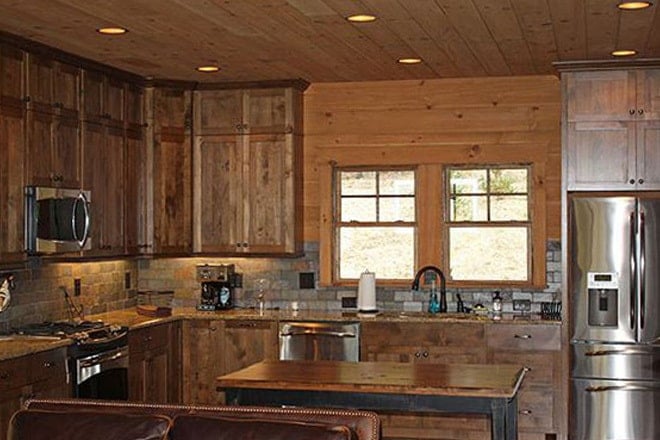 The kitchen is equipped with stainless steel appliances, granite countertops, wooden cabinets, and a center island.