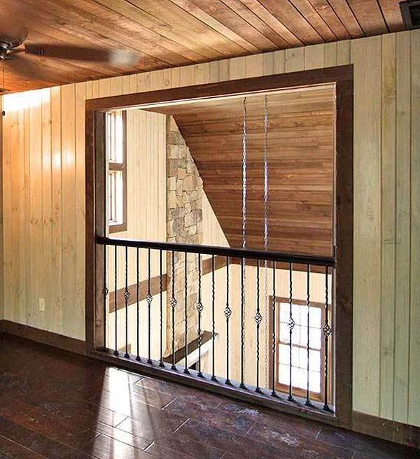 This bedroom has wrought iron railings overlooking the living room below.