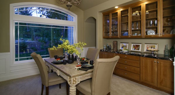 A large wooden display cabinet with a black marble countertop completes the dining area.