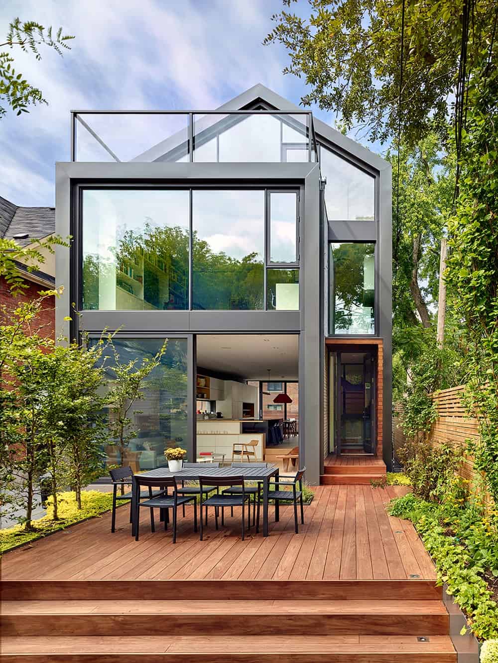 This is a look at the back of the house that is dominated by large laminated glass walls complemented by the surrounding landscape.