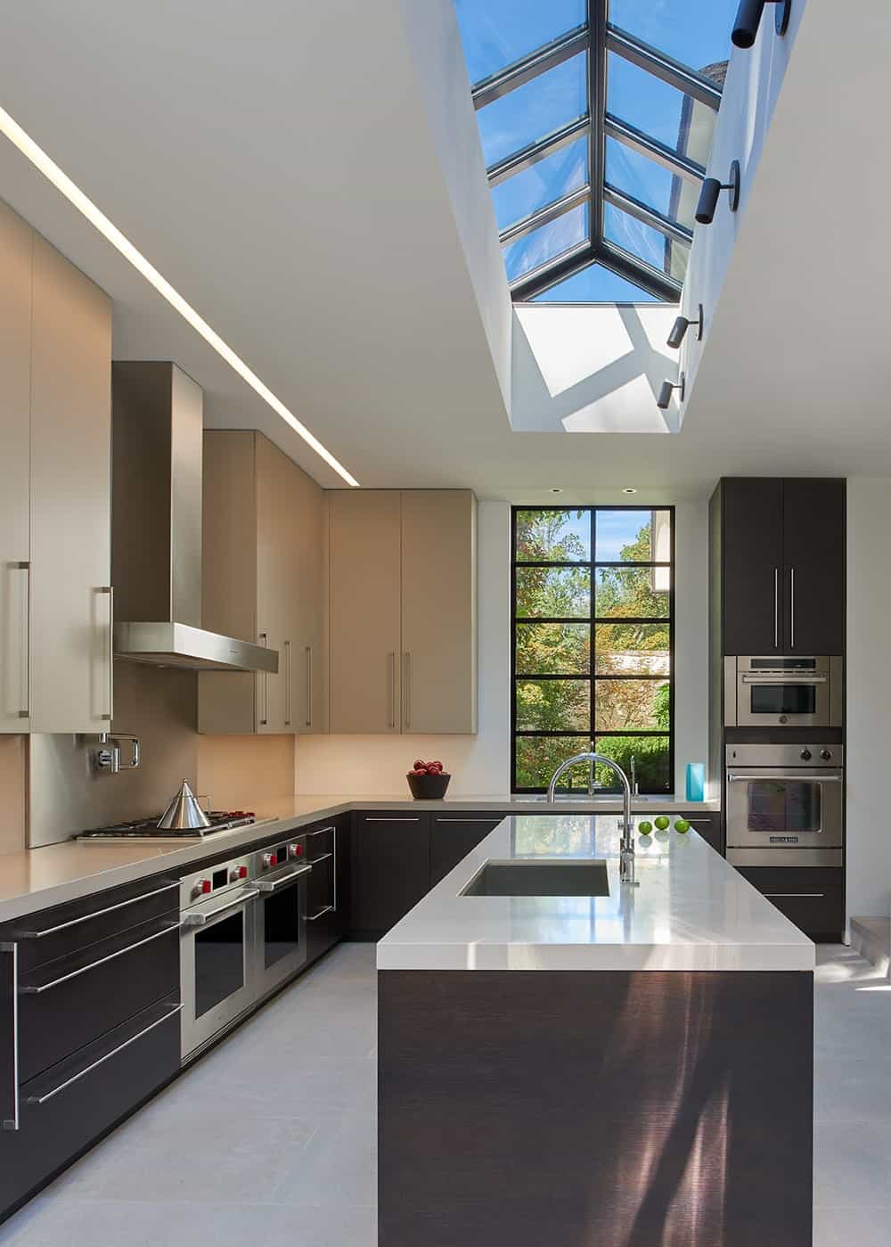 The kitchen is illuminated by the large cathedral skylight above the kitchen island that brings in an abundance of natural lighting.