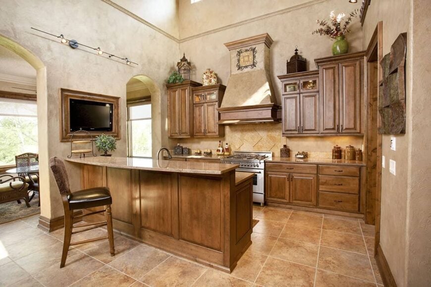 The kitchen is equipped with stainless steel range, wooden cabinetry, and a two-tier island.