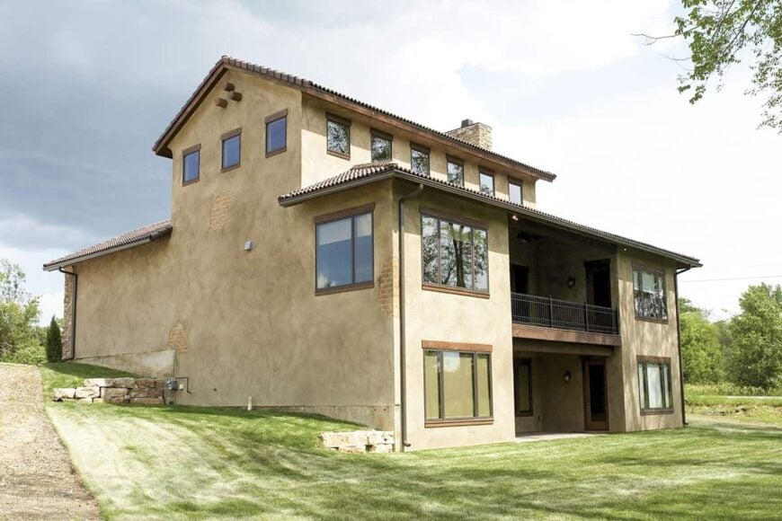 Rear exterior view showing the sloping lot along with covered porch and patio.