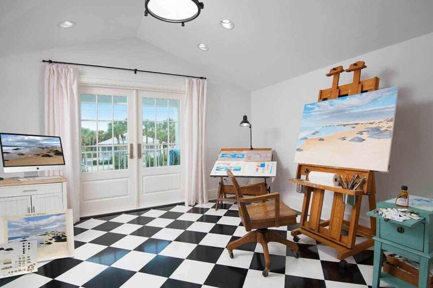 Studio with art tools, checkered flooring, and a french door that leads out to the covered balcony.
