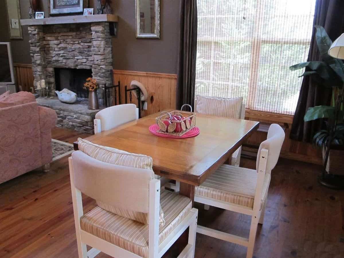 Dining area with a wooden dining table and white cushioned chairs.