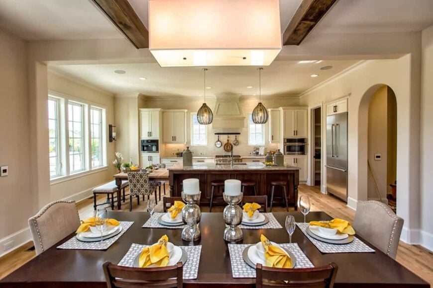 View of the kitchen from the dining area well-lit by a warm chandelier.