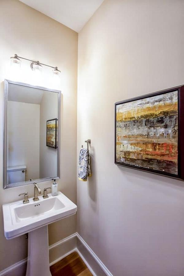 
A large glass vase, candle holders, and a framed painting complement the glass-enclosed fireplace.