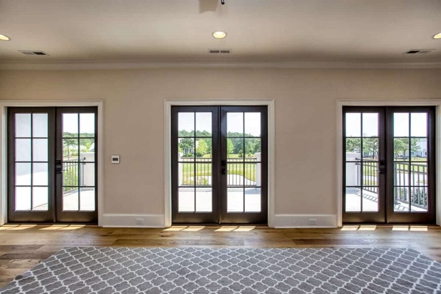 Recreation room with a huge patterned rug and three french doors that lead out to the spacious balcony.