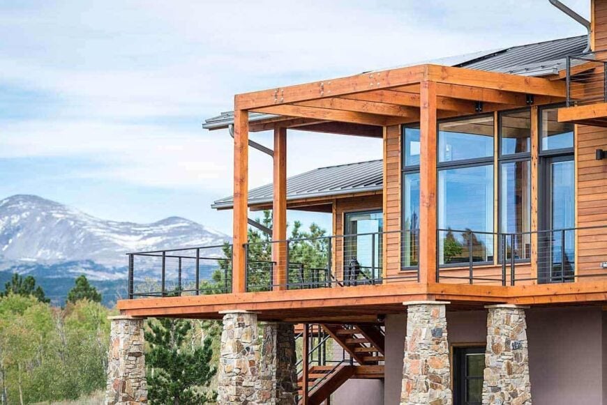 Rustic wood beams and wrought iron railings frame the side deck.