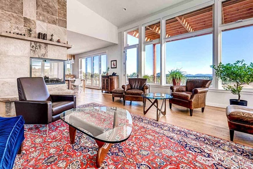 The great room has a vaulted ceiling and hardwood flooring topped by a classic red area rug.