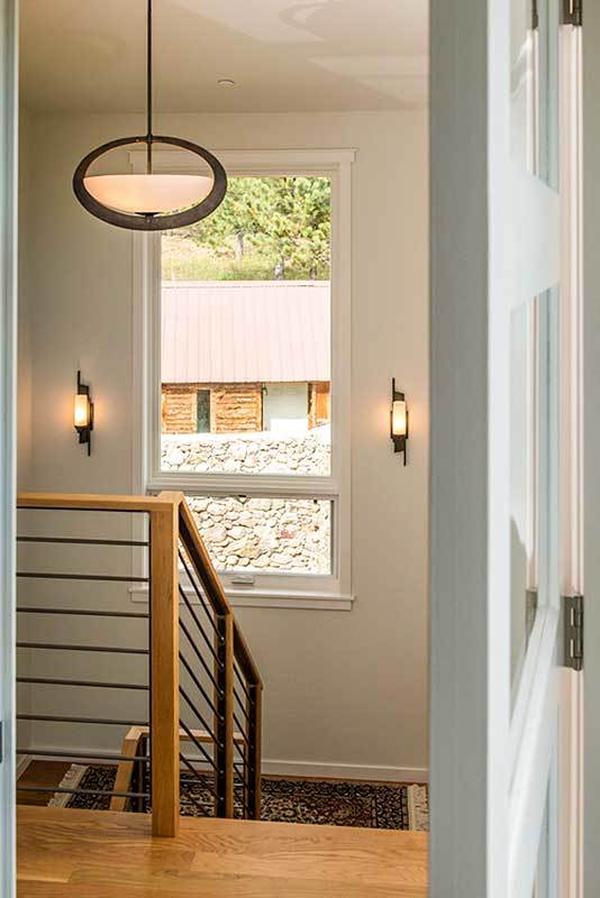 Staircase landing with cylindrical sconces and a picture window overlooking the courtyard.