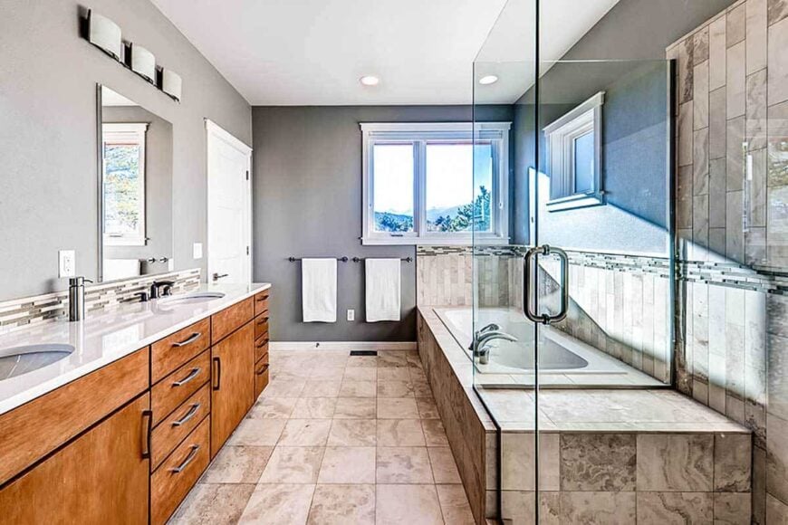 The primary bathroom has a walk-in shower, a dual sink vanity, and a deep soaking tub.