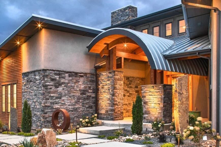 Home entry with concrete walkway, double columns, and an arched roof.