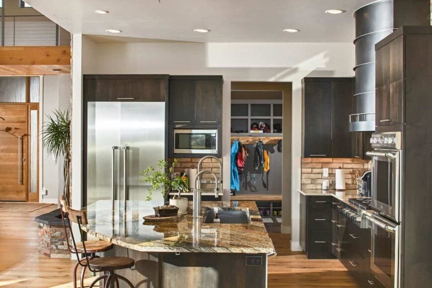 The kitchen island is fitted with an undermount sink and gooseneck faucets.