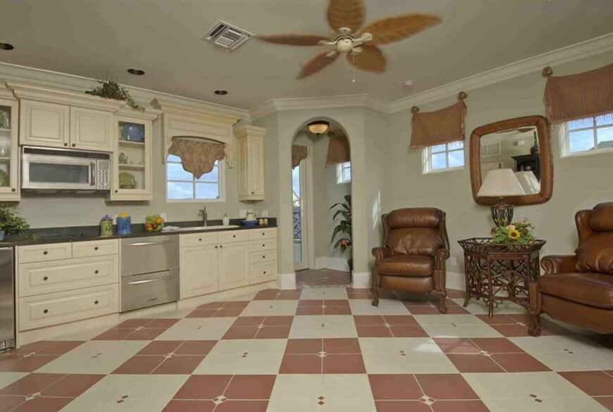 Studio with leather seats, a wicker side table, framed mirror, and a kitchenette.