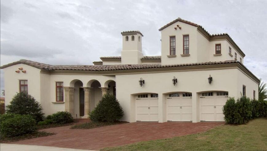 Side exterior view showing the loggia and three-car garage topped with outdoor sconces.