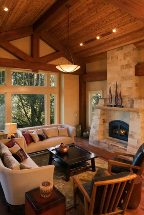 The living room has beige sofas, leather cushioned chairs, a stone fireplace, and a glass dome pendant hanging from the cathedral ceiling.