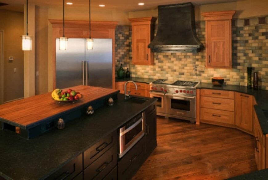 The kitchen is equipped with stainless steel appliances, linear mosaic tile backsplash, black granite countertops, and a two-tier island.