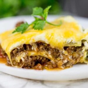 A slice of taco lasagna with melted cheese on top and layers of meat.