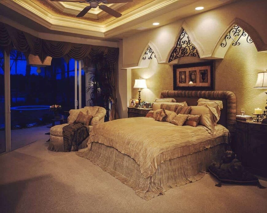 The primary bedroom has wooden furnishings, carpet flooring, a step ceiling, and covered lanai access.