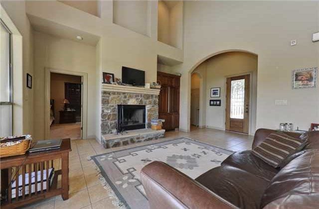 A stone fireplace topped with a TV complete the living room.