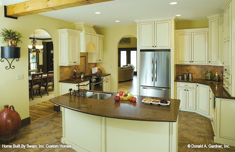The kitchen is equipped with cream cabinets, stainless steel appliances, granite countertops, and a double bowl sink fitted on the prep island.