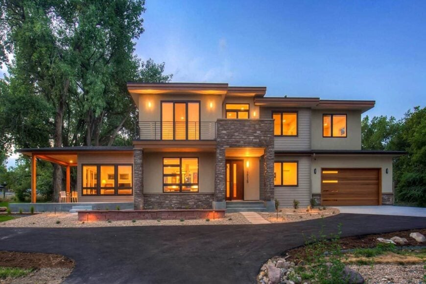 Front exterior view with stucco and stone siding, covered entry, and a double garage.