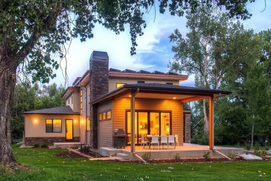 The side porch is filled with a summer kitchen and an outdoor dining set.