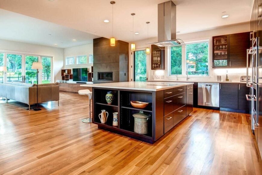 View of the open kitchen and living room surrounded by glazed windows and doors.