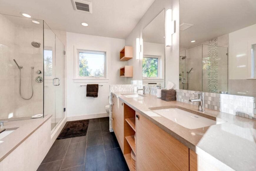 Primary bathroom with a walk-in shower, a deep soaking tub, and a toilet concealed by the dual sink vanity.