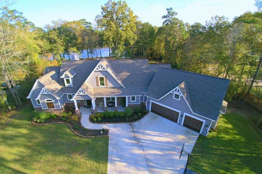 Aerial view of the house showing the gable rooflines and a concrete driveway nestled in between the verdant lawn.
