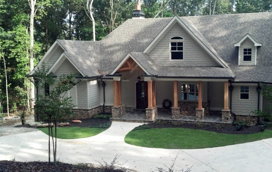 Alternate front exterior with neutral shakes, multiple gables, and tapered columns.
