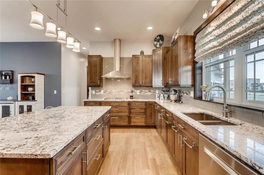 White framed windows dressed in a patterned roman shade bring natural light in.
