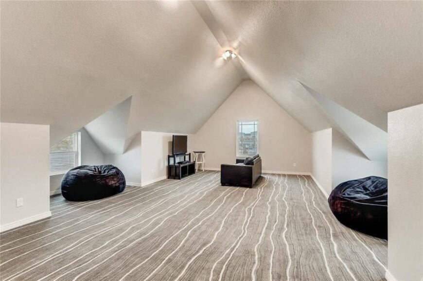 The bonus room is filled with a leather sofa, TV, and black bean bags.The bonus room is filled with a leather sofa, TV, and black bean bags.