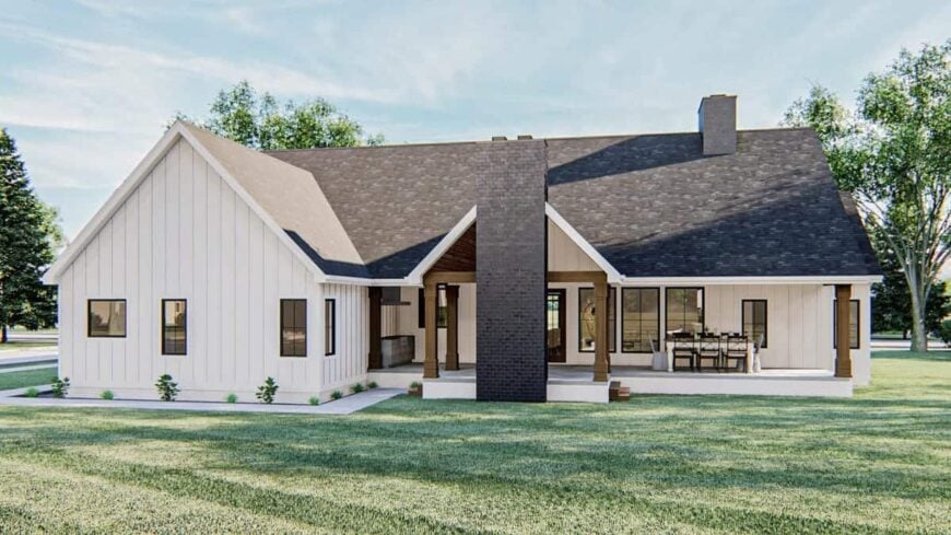 Rear exterior view with a covered patio warmed by a stone fireplace.