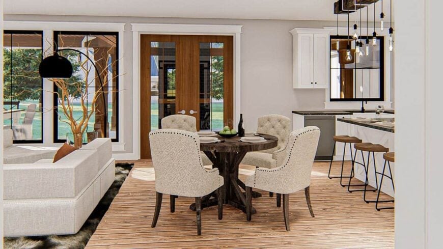 Breakfast area with a round dining table and beige tufted chairs. It sits in between the kitchen and living room.