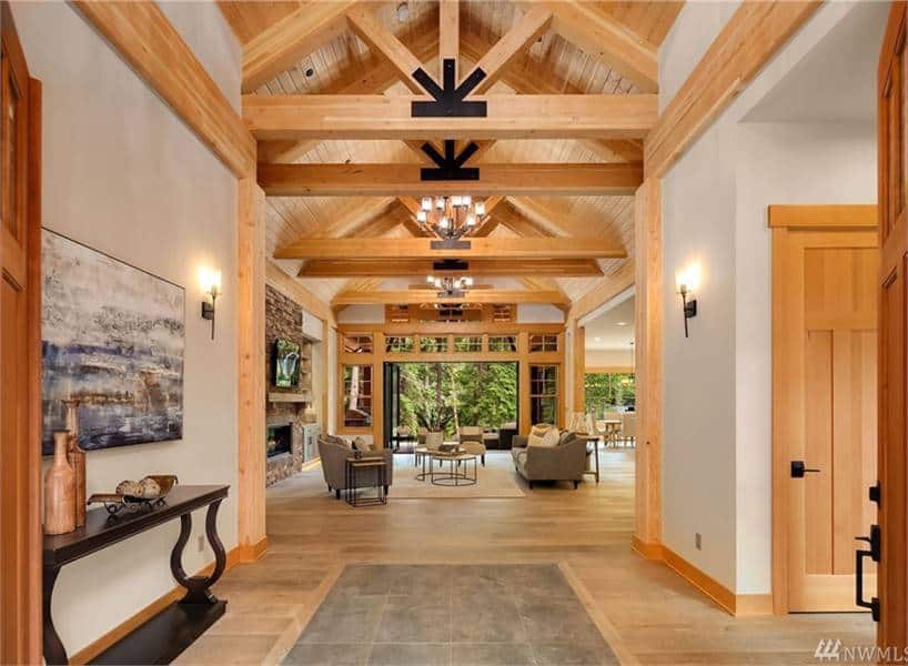 The foyer has a dark wood console table, an abstract painting, and a great view of the open living space ahead.