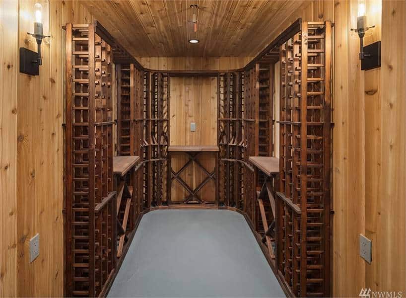 The wine cellar is filled with wooden wine racks arranged in columns and crisscross patterns.