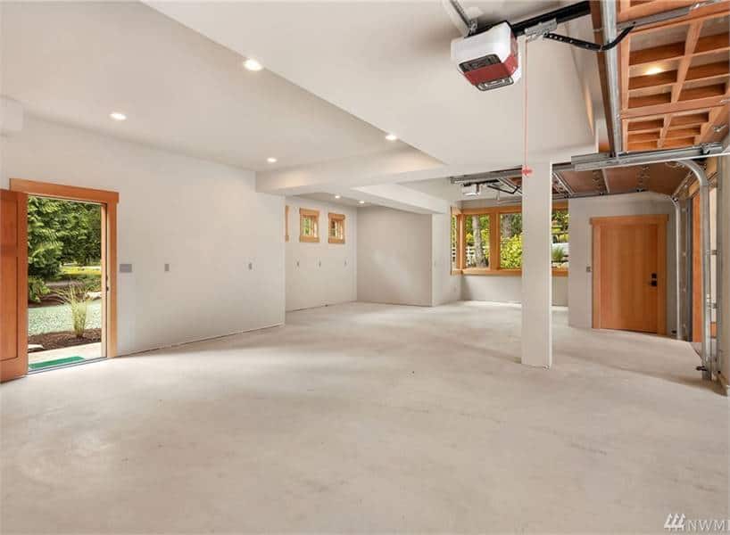 Oversized garage with white walls, concrete flooring, and a storage closet.