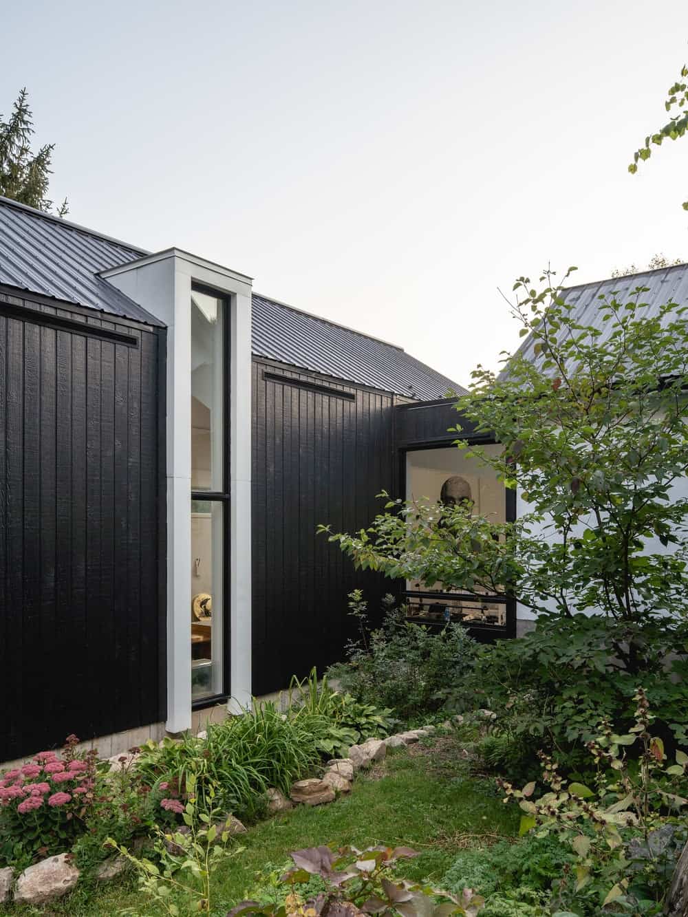 This is de of the house extension showcases more of the house extension and its tall window and bridge that connects it to the main house.