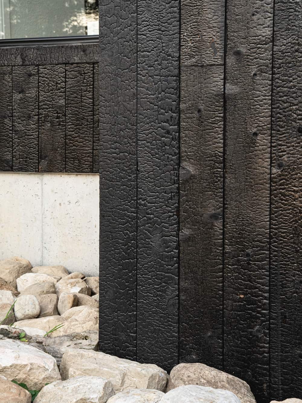 This is a close look at the textured wooden dark exterior walls of the house extension.