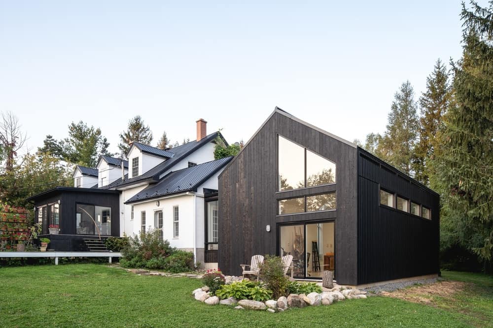The back of the house shows more of the simple and modern designs of the extension structure in contrast with the more traditional look and light tones of the main house.
