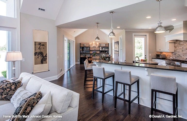 An open layout view of the living room, kitchen, and dining area.